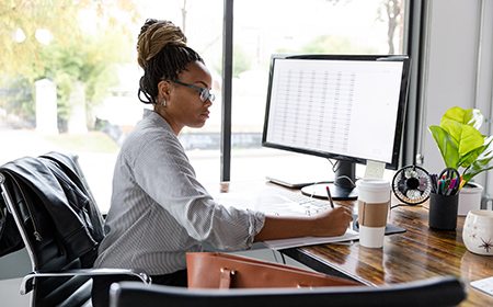 Photo of a woman working on a desktop computer