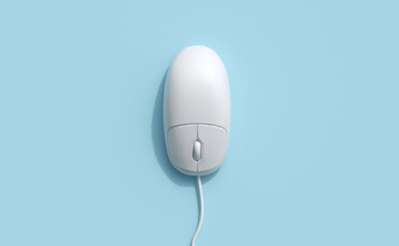 Photo of a white computer mouse on a blue background.